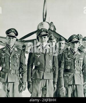 Ein Foto zeigt drei deutsche Luftwaffenoffiziere, Hauptmann Preßler, Oberleutnant Stepp und Oberleutnant Kaiser, die in Formation vor einem Junkers Ju 87 (Stuka)-Flugzeug stehen. Während der Operation Barbarossa 1941 wurden diese Offiziere mit dem Ritterkreuz für ihre heldenhaften Aktionen als Stuka-Piloten ausgezeichnet. Stockfoto