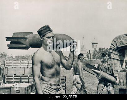 Ein Foto zeigt einen deutschen Soldaten, der eine Bombe auf der Schulter trägt und sich darauf vorbereitet, Flugzeuge an ihren Parkplätzen aufzufüllen. Dieses Bild wurde 1941 während der Operation Barbarossa aufgenommen und zeigt die anhaltenden Bemühungen, Luftwaffenflugzeuge zu bewaffnen, während die deutschen Truppen während des Zweiten Weltkriegs gegen sowjetische Truppen an der Ostfront vorrückten. Stockfoto