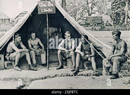 Ein Foto zeigt eine Gruppe deutscher Soldaten, die für die Wiederaufrüstung von Flugzeugwaffen verantwortlich sind, während sie einen Moment der Stillstandszeit auf die Rückkehr der Flugzeuge von einer Mission warten. Dieses Bild wurde 1941 während der Operation Barbarossa aufgenommen und zeigt die entscheidende Rolle der Luftwaffe beim deutschen Vormarsch gegen die sowjetischen Truppen an der Ostfront während des Zweiten Weltkriegs. Stockfoto