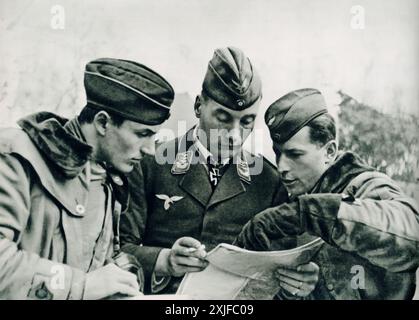 Ein Foto zeigt den Empfänger des Ritterkreuzes Captain von Rettberg, der eine Karte während der Operation Barbarossa 1941 untersucht. Diese Szene veranschaulicht die strategische Planung und Koordination, die erforderlich war, als deutsche Truppen während des Zweiten Weltkriegs gegen sowjetische Truppen an der Ostfront vorrückten. Stockfoto