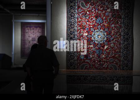 Teheran, Iran. Juli 2024. Besucher sehen einen Teppich in einem Teppichmuseum in Teheran, Iran, 18. Juli 2024. Quelle: Shadati/Xinhua/Alamy Live News Stockfoto