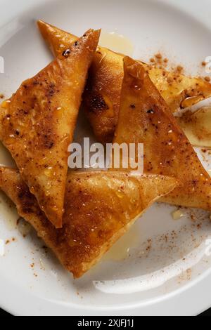 Kleinkäsekuchen mit Myzithra, kretischem Honig und Zimt. Stockfoto