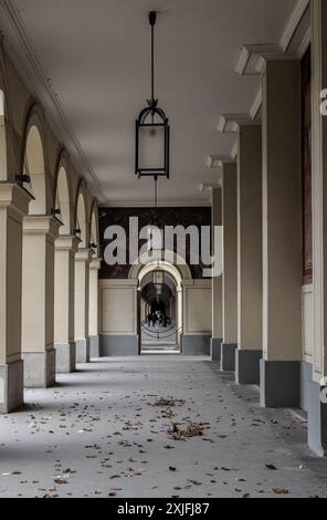 München, Deutschland - 21. Dezember 2023 - perspektivischer Blick auf den langen Korridor mit antiker Laterne, die von der Decke hängt, und wunderschönen Säulen im Hofgartenark Stockfoto