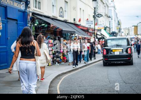 LONDON - 1. JULI 2024: Geschäftige Market Street Szene an der Portobello Road, einer Wahrzeichen Markt- und Einkaufsstraße im Zentrum von West London Stockfoto