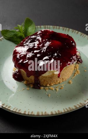 Hausgemachter Mini-Käsekuchen auf Teller auf dunklem Hintergrund. Stockfoto