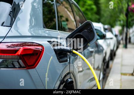 Ein Elektroauto, das in einer Wohnstraße im Zentrum von London aufgeladen ist Stockfoto