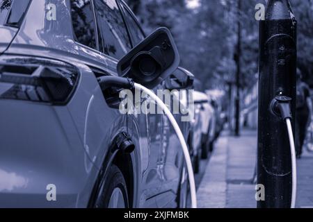 Ein Elektroauto, das in einer Wohnstraße im Zentrum von London aufgeladen ist Stockfoto