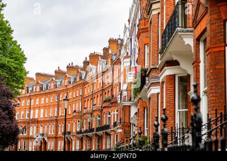 LONDON – 10. JULI 2024: Elegante Londoner Herrenhäuser aus roten Backsteinen in Knightsbridge und Chelsea Stockfoto