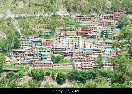 Farbenfrohe Gebäude eingebettet in die malerische, hügelige Landschaft von Himachal Pradesh, Indien Stockfoto