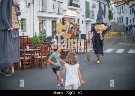 Kinder genießen die traditionelle Gigantes y Cabezudos Parade während des Festivals in Fuenteheridos, Huelva, Andalusien, Spanien. Festliche Atmosphäre mit gia Stockfoto