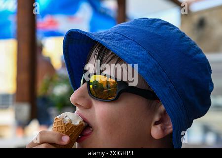 Der kleine Junge genießt an einem Sommertag im Freien eine Eiscreme. Stockfoto