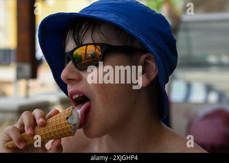 Der kleine Junge genießt an einem Sommertag im Freien eine Eiscreme. Stockfoto