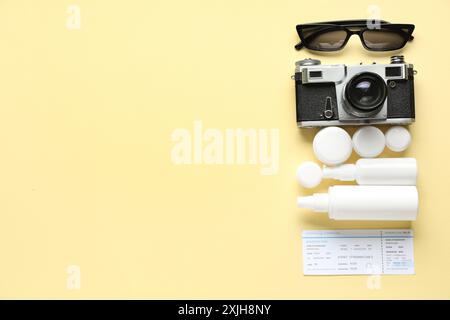 Komposition mit kosmetischem Reiseset, weiblichen Strandaccessoires, Ticket und Fotokamera auf farbigem Hintergrund Stockfoto