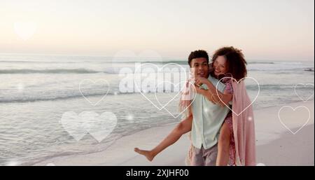 Bild von Herzen, die sich über verschiedene verliebte Paare am Strand im Sommer bewegen Stockfoto
