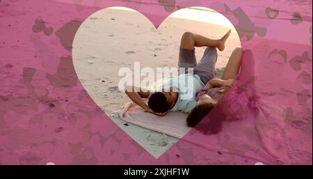 Bild von Herzen, die sich über verschiedene verliebte Paare bewegen, die im Sommer am Strand liegen Stockfoto