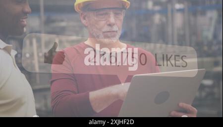 Mithilfe eines Laptops, eines Fabrikarbeiters mit Schutzhelm und einer Brille gefällt das Bild in sozialen Medien Stockfoto