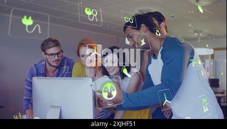 Bild von ökologischen Symbolen über verschiedenen Kollegen, die ein Tablet im Büro verwenden Stockfoto