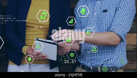 Bild von ökologischen Symbolen über verschiedenen Kollegen, die ein Tablet im Büro verwenden Stockfoto