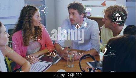Bild von ökologischen Symbolen über verschiedenen Kollegen bei Besprechungen im Büro Stockfoto