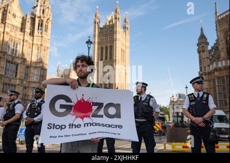 London, Großbritannien. Juli 2024. Ein pro-palästinensischer Demonstrant hält während der Kundgebung ein Plakat mit der Aufschrift "Gaza stoppt das Massaker". Pro-palästinensische Aktivisten versammelten sich auf dem Parlamentsplatz und schlossen sich dem Parlament an, um gegen den Krieg in Gaza zu protestieren und um einen sofortigen Waffenstillstand zu bitten. Quelle: SOPA Images Limited/Alamy Live News Stockfoto