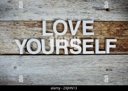 Liebe dich selbst Alphabete auf hölzernem Hintergrund Stockfoto