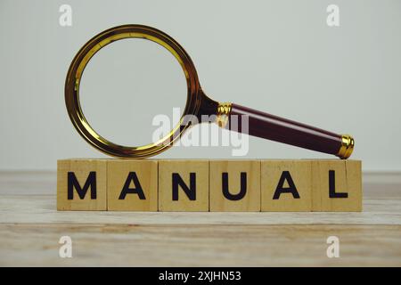 Lupe mit Holzblöcken Alphabet Buchstaben MANUELL auf hölzernem Hintergrund Stockfoto
