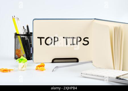 TOP-TIPPS für konzeptionelle Symbole. Kopierbereich. Top-Tipps Wörter, die in einem Notizbuch auf einem Tisch auf hellem Hintergrund geschrieben sind Stockfoto
