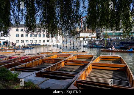 Cambridge, Großbritannien - 8. Oktober 2023 : Holzdünen werden entlang des Flusses Cam in Cambridge, Großbritannien angedockt. Die Sonne scheint auf dem Wasser und reflektiert die nahe gelegenen Bu Stockfoto