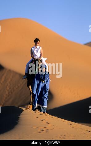 SÜDMAROKKO, REGION TAFILALET, KAMELRITT IN DEN DÜNEN VON MERZOUGA (ERG CHEBBI) Stockfoto