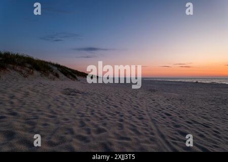 Ein schöner, breiter Strand an der Ostsee. Blaue Stunde. Der Himmel ist heiß. Dünen, die mit Vegetation am Meer bedeckt sind. Slajszewo, Polen Stockfoto