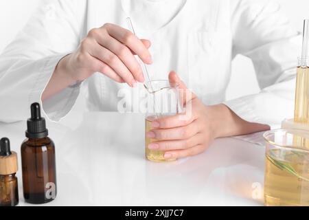 Aromatherapeutikum. Wissenschaftler, der ätherische Öle am weißen Tisch im Labor entwickelt, Nahaufnahme Stockfoto