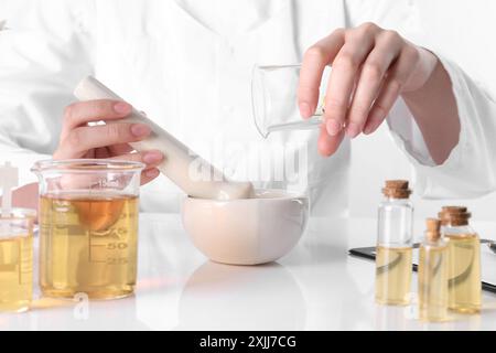 Aromatherapeutikum. Wissenschaftler, der ätherische Öle am weißen Tisch im Labor entwickelt, Nahaufnahme Stockfoto