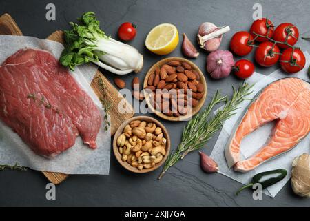 Flache Lagen mit frischem Fleisch und anderen Produkten für eine ausgewogene Ernährung auf schwarzem Tisch Stockfoto