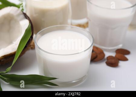 Verschiedene Arten veganer Milch und Zutaten auf weißem Tisch, Nahaufnahme Stockfoto