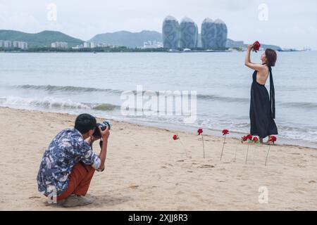 Sanya, Chinas Provinz Hainan. Juli 2024. Ein Tourist posiert für Fotos in einer malerischen Gegend an einer Küste in Sanya, südchinesischer Provinz Hainan, 18. Juli 2024. Quelle: Zhang Liyun/Xinhua/Alamy Live News Stockfoto