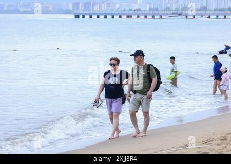 Sanya, Chinas Provinz Hainan. Juli 2024. Ausländische Touristen besuchen ein landschaftlich reizvolles Gebiet an einer Küste in Sanya, südchinesischer Provinz Hainan, 18. Juli 2024. Quelle: Zhang Liyun/Xinhua/Alamy Live News Stockfoto