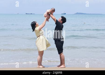 Sanya, Chinas Provinz Hainan. Juli 2024. Touristen besuchen ein landschaftlich reizvolles Gebiet an einer Küste in Sanya, südchinesischer Provinz Hainan, 18. Juli 2024. Quelle: Zhang Liyun/Xinhua/Alamy Live News Stockfoto