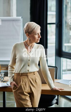 Geschäftsfrau mittleren Alters im modernen Büro, die an einem polierten Holztisch steht. Stockfoto