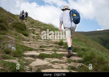 Wanderer klettern am 17. Juli 2024 auf dem Weg zum Kinder Scout auf den unteren Etappen des Pennine Way in Edale, Derbyshire, England. Stockfoto