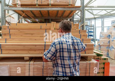 Senior-Mann, der Holz in einem Eisenwarenladen auswählt Stockfoto