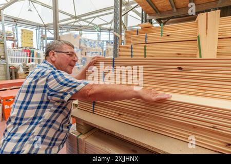 Senior-Mann, der Holz in einem Eisenwarenladen auswählt Stockfoto