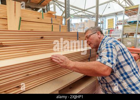 Senior-Mann, der Holz in einem Eisenwarenladen auswählt Stockfoto