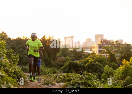 Zwei Freunde laufen mit einer Skyline im Hintergrund. Stockfoto