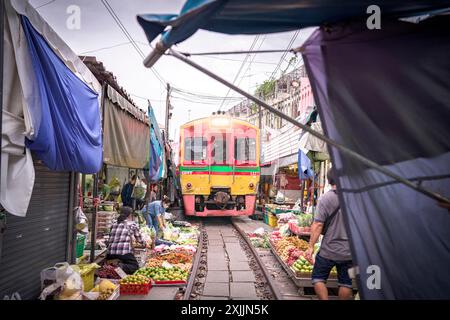 Zug auf schmalen Gleisen am Maeklong Railway Market, Bangkok Stockfoto