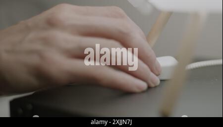 Nahaufnahme der weiblichen Hand, die das Licht ausschaltet, den Lampenschalter am Nachttisch berührt und nachts schläft. Zeit-Schlaf-Konzept. Stockfoto