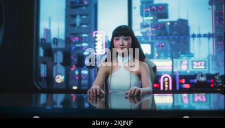 Stilvolle japanische junge Frau, die mit der Augmented-Reality-Plattform in einem technologisch fortschrittlichen Raum interagiert. Sie nutzt Glass Interactive Desk mit Futuristic Cyberpunk City im Hintergrund. Stockfoto