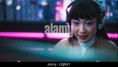 Junge aufgeregte japanische Gamer Girl Porträt in einem hellen Neonraum. Stilvolle asiatische Frau mit auffälligem Make-up beim Spielen und Streaming von Videospielen. E-Sports Professional spielt ein Online-Turnier Stockfoto