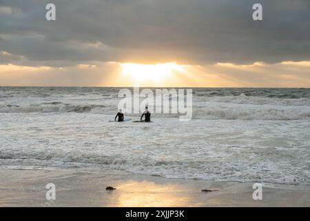 Zwei Surfer im Meer bei Sonnenuntergang in Florida Stockfoto