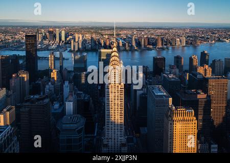 Blick aus der Vogelperspektive auf das berühmte Chrysler Building und andere Wolkenkratzer in Manhattan in der Abenddämmerung, New York City. Diese atemberaubende Szene fängt die Lichter der Stadt ein Stockfoto