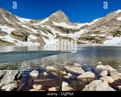 Ein gefrorener See mit einem schneebedeckten Berg Stockfoto